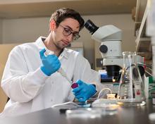 Student works with equipment in an chemical lab