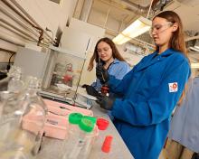 Two students with chemicals in a lab